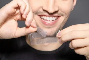 man removing whitening strips ready for use